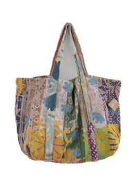 Farverig patchwork-broderet tote-taske med blomstermønstre og quiltede stofskulderstropper på hvid baggrund